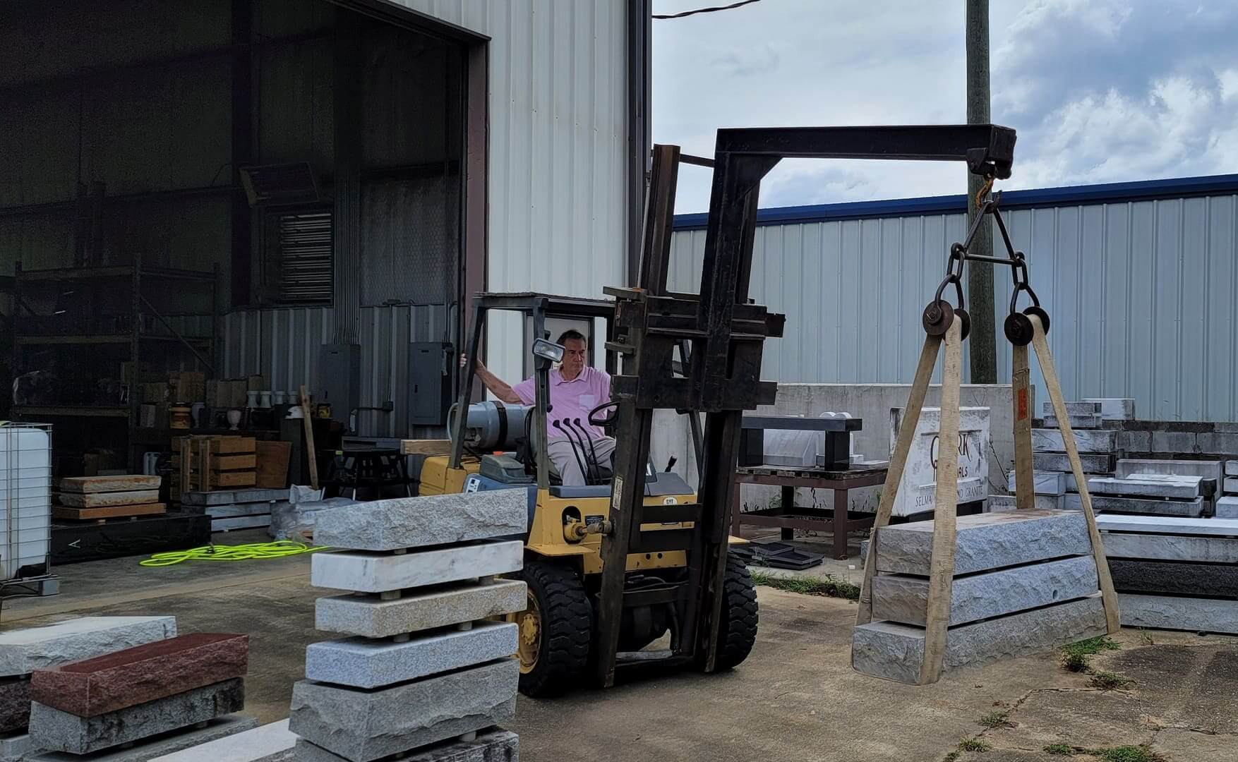 A forklift moving finished stone inside the plant
